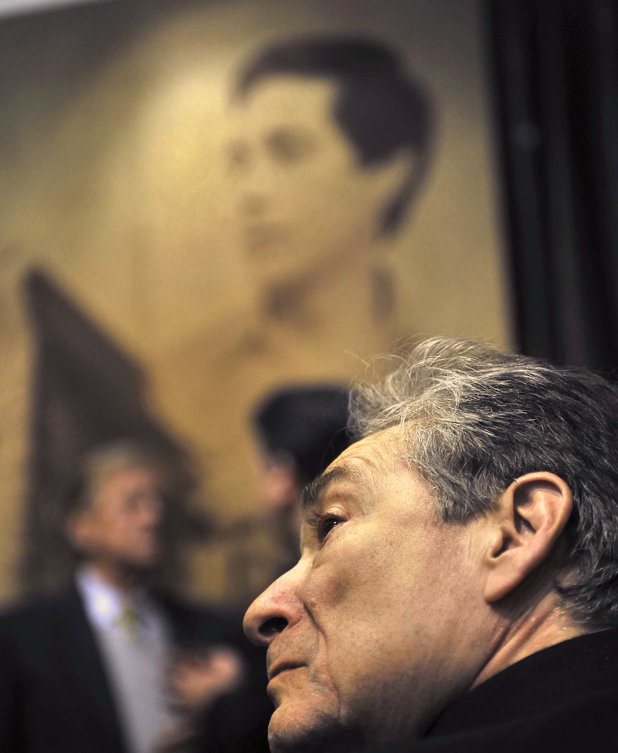 Photo of Maya Romanoff before his potrait in the background.  